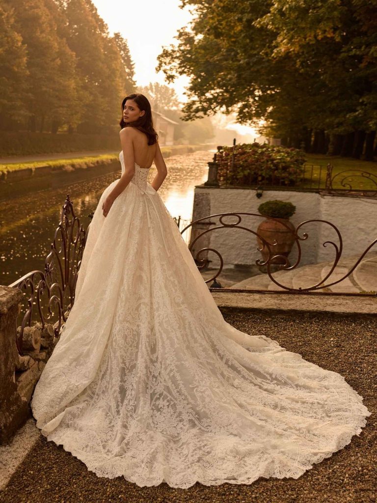 Sposa con abito romantico e lungo strascico in pizzo